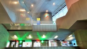 The atrium which houses the escalators that link street level to the bridge which spans the station