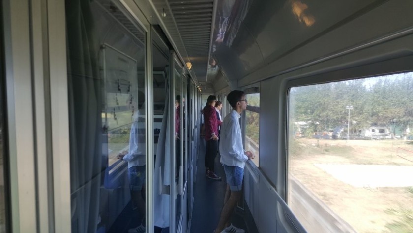 Travellers have stepped out into the corridor on the IC train in order to take in the coastal views