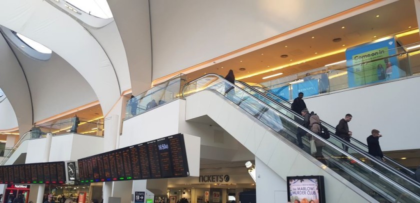 The ticket desks and machines are behind the main departure board