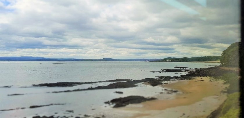 Shortly after the train has travelled over the bridge the railway is by the shoreline