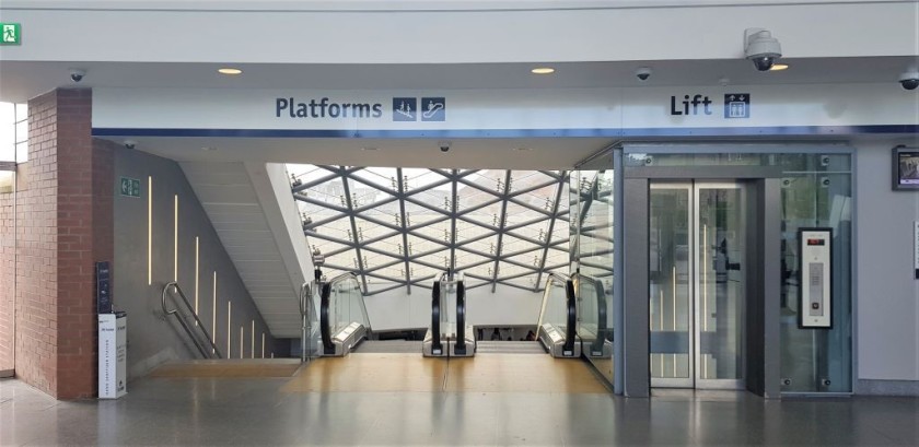 Escalators and a lift connect the entrance hall to the trains