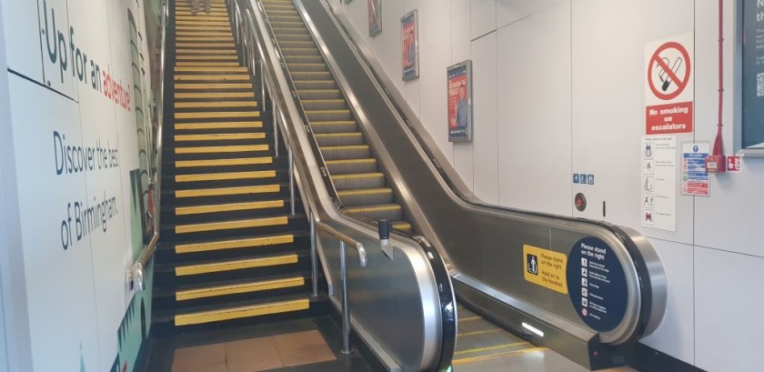 The escalator leads up from the trains