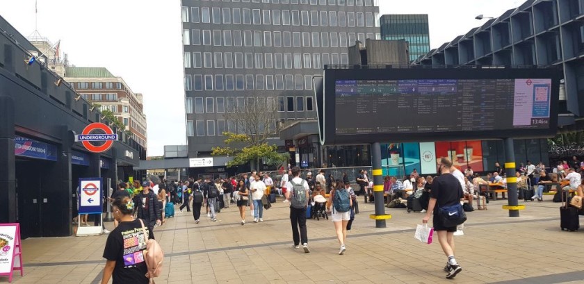 The escalators access is by the sign on the plaza in front of the station