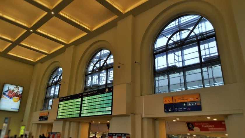 From the main entrance hall the passage that leads to the trains is underneath the main departure board