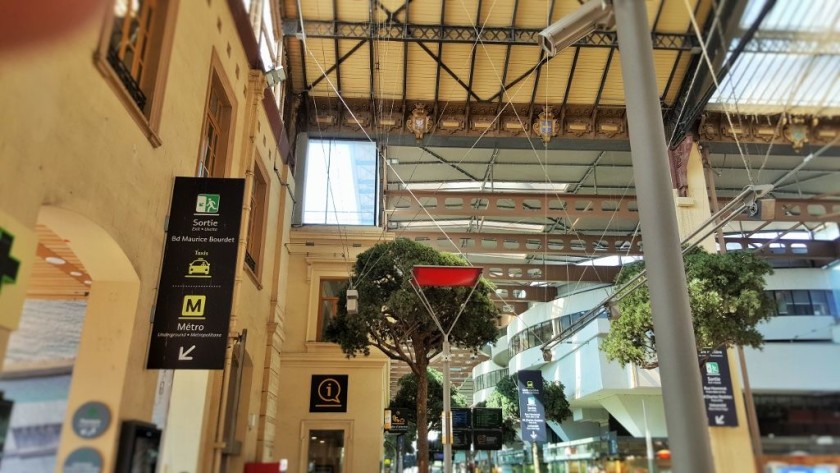 Looking across the tree line concourse, the voies are on the right, the access to the metro is to the left