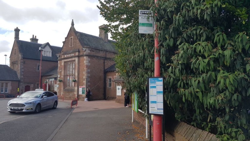 The buses depart from a stop on the station forecourt