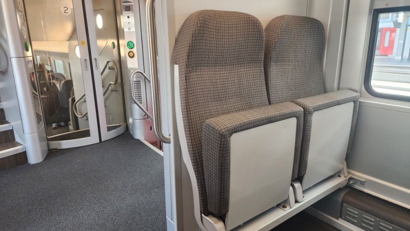 The seating bay inside the doors on a double deck Belgian IC train