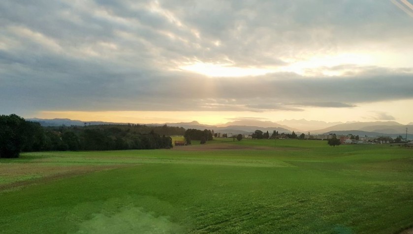 The sun rises over the countryside near Fribourg from an IC 1 train