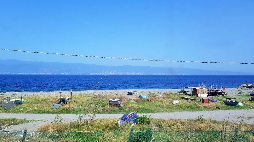 Travelling along the east coast of Sicily on the train from Rome and Naples